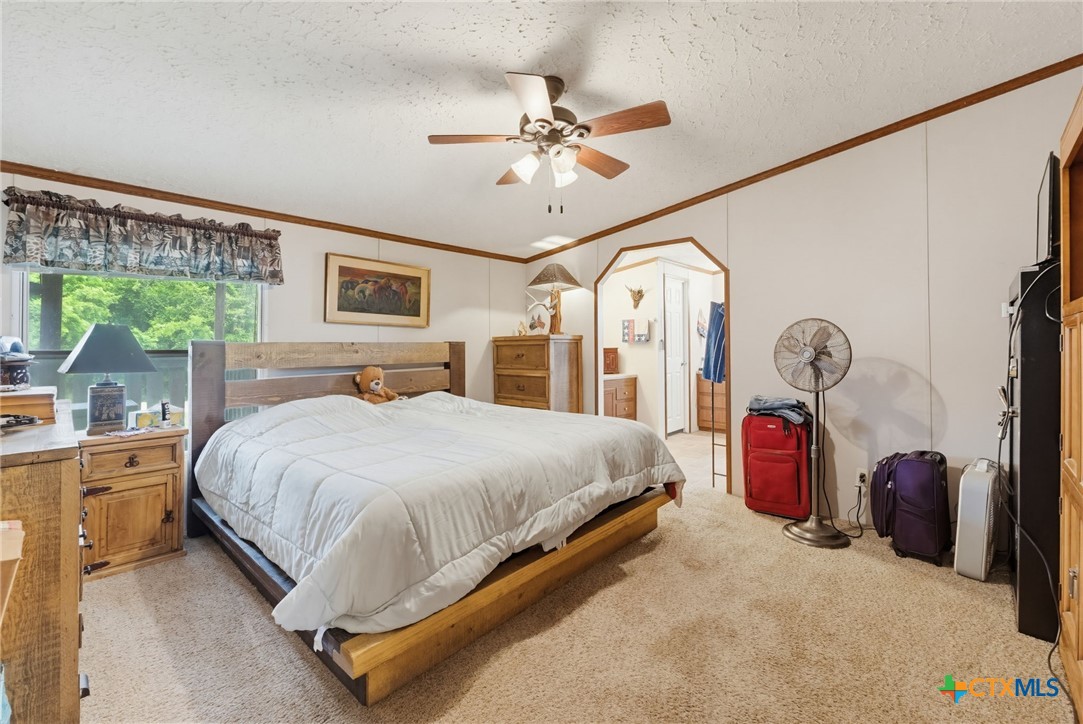 164 County Road 4450 Kempner, TX 76539 - Photo 14 of 44 a spacious bedroom with a bed mirror on desk and a large window