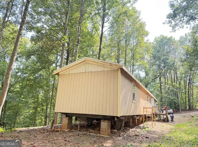 a view of a small house with a yard and roof