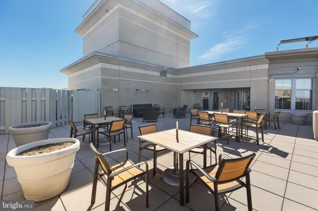 a living room with furniture a fireplace and potted plants with wooden floor