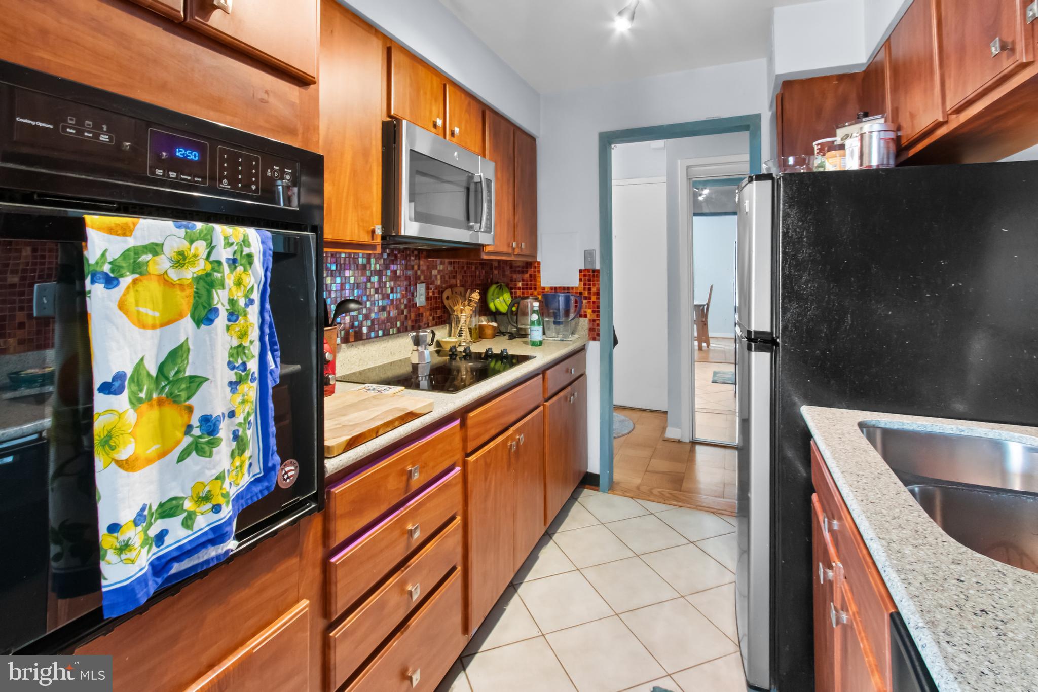 2501 Calvert Street Northwest, Unit 708 Washington, DC 20008 - Photo 15 of 21 a kitchen with stainless steel appliances granite countertop a sink and a refrigerator