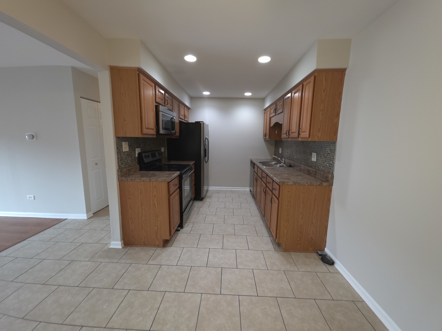 412 East Bailey Road, Unit 101 Naperville, IL 60565 - Photo 5 of 12 a kitchen with a sink a stove top oven and cabinets