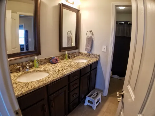 a bathroom with a granite countertop sink and a mirror