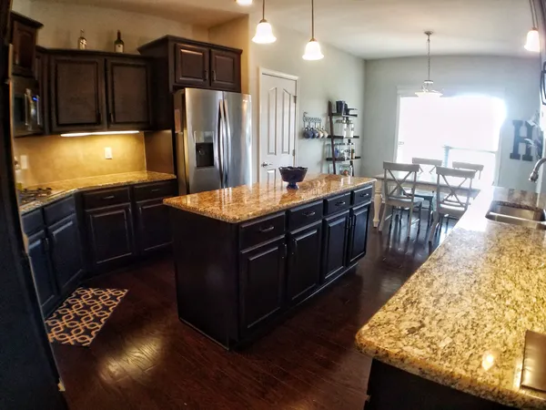 a kitchen with stainless steel appliances granite countertop a stove a refrigerator and a sink