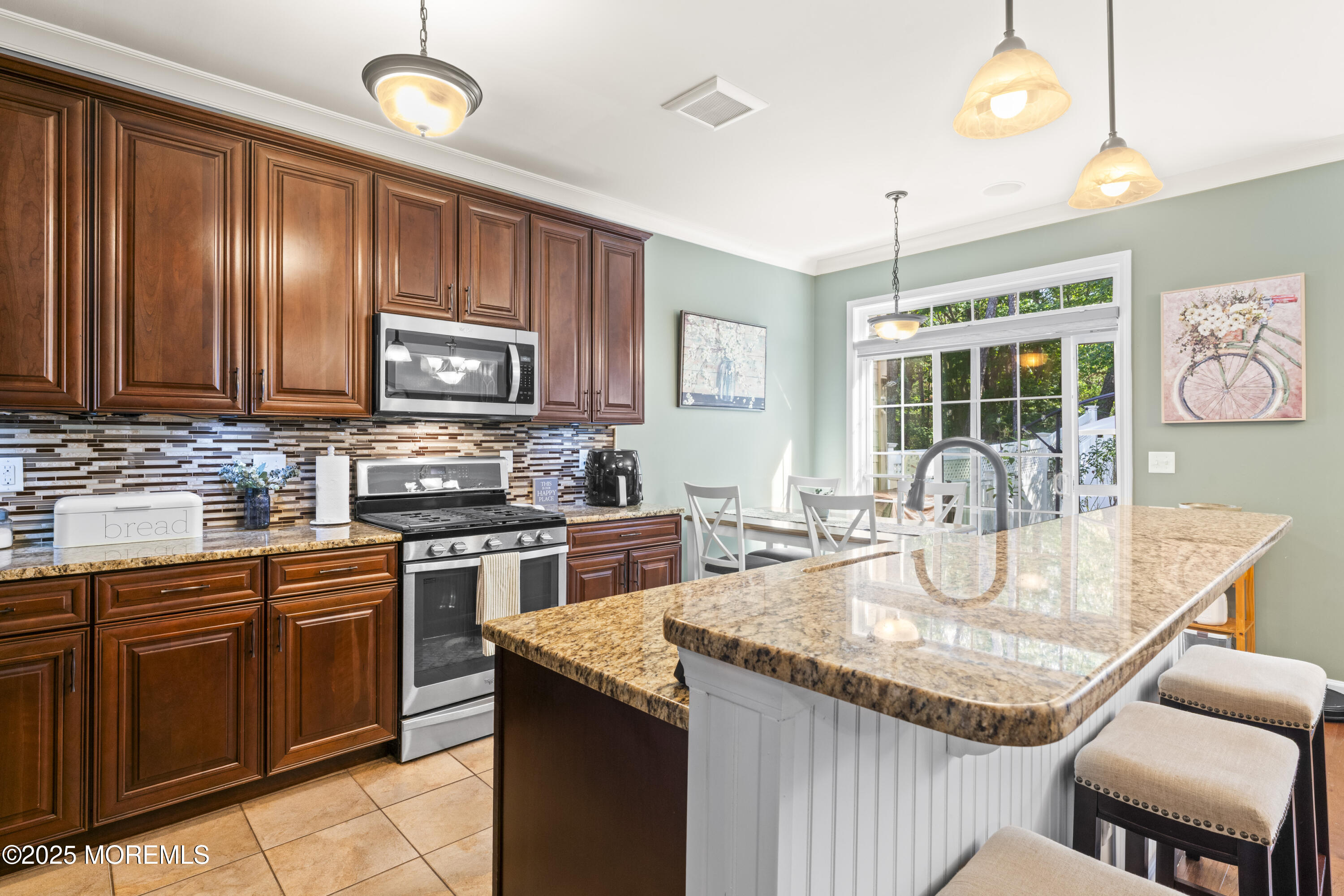 206 Hawthorne Lane Barnegat, NJ 08005 - Photo 11 of 49 a kitchen with kitchen island granite countertop wooden cabinets a stove top oven a granite counter space and a window