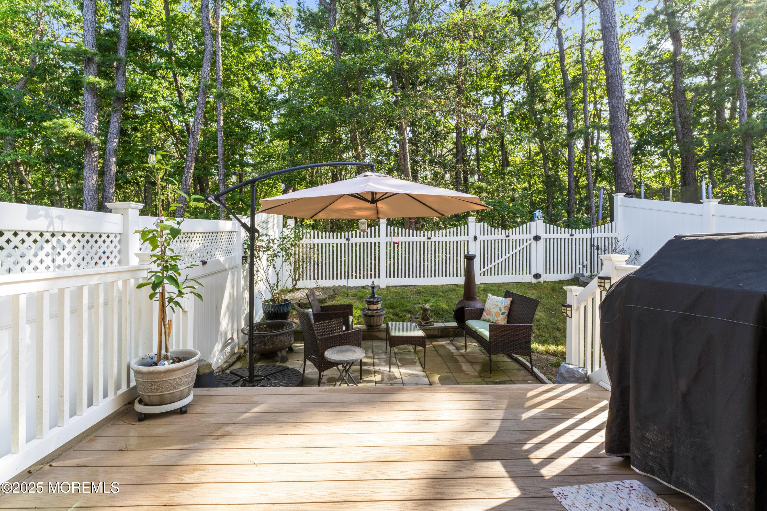 206 Hawthorne Lane Barnegat, NJ 08005 - Photo 34 of 49 a view of a patio with table and chairs under an umbrella with wooden fence