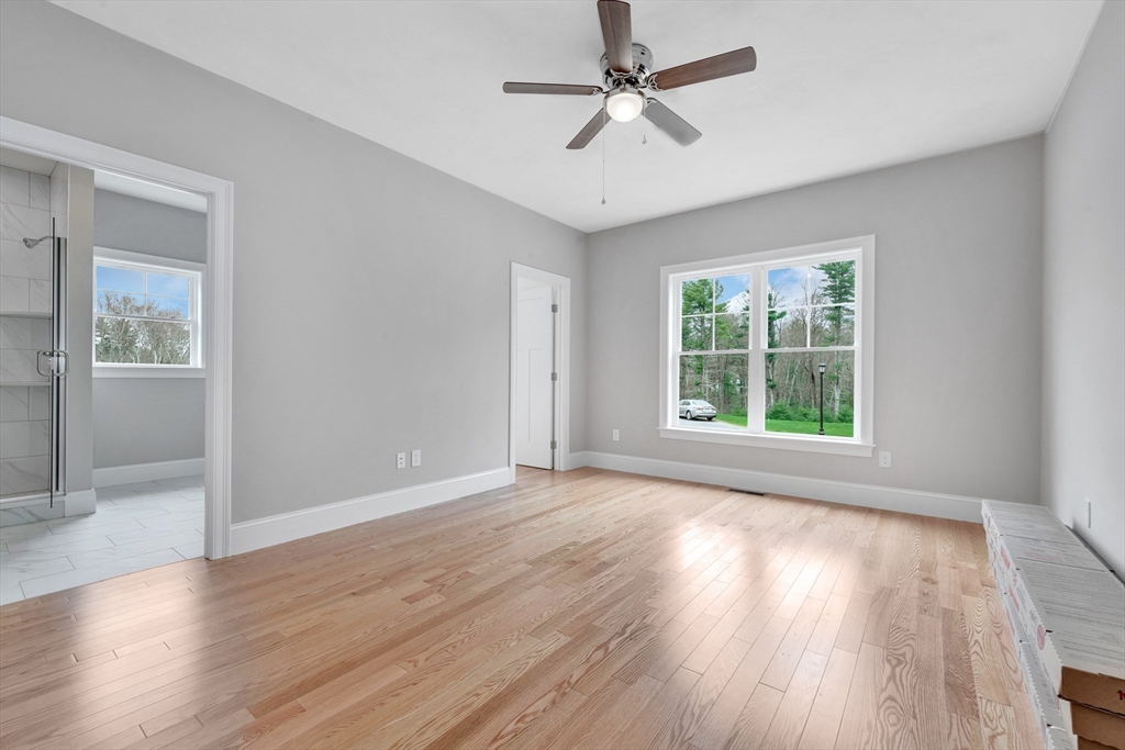 8 Weber Farm Road, Unit 8 Wrentham, MA 02093 - Photo 31 of 35 an empty room with wooden floor chandelier fan and windows