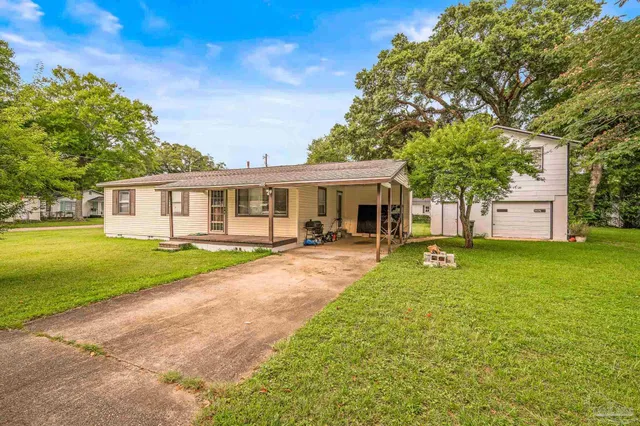 a view of a house with a yard and tree s