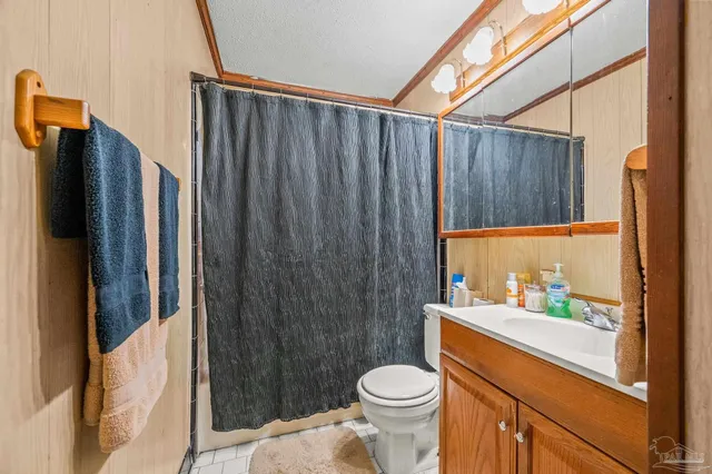 a bathroom with a sink a toilet a shower and a window