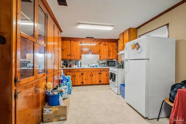 a kitchen with a refrigerator a stove top oven a sink and a large window