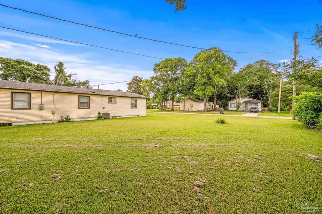 a view of a house with garden and a trees