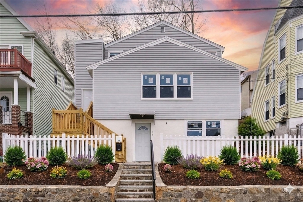 a front view of a house with a garden