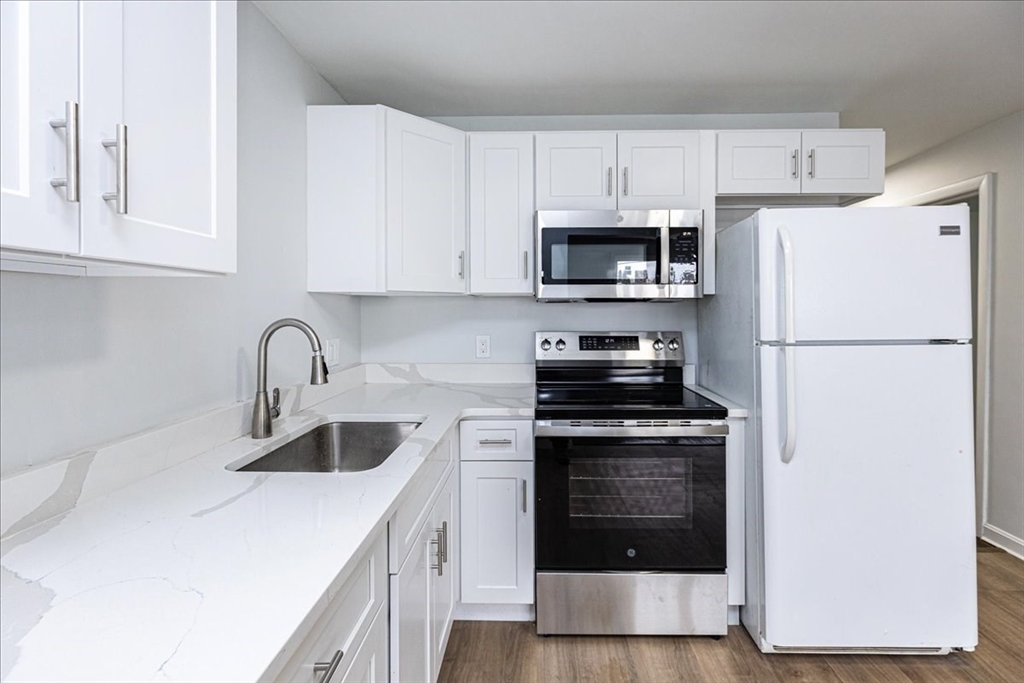 38 Warren Street Revere, MA 02151 - Photo 11 of 42 a kitchen with white cabinets and stainless steel appliances