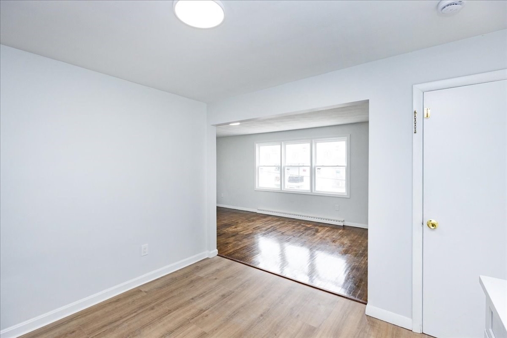 38 Warren Street Revere, MA 02151 - Photo 12 of 42 an empty room with wooden floor and windows
