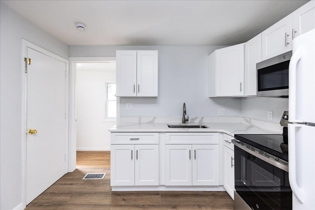 38 Warren Street Revere, MA 02151 - Photo 13 of 42 a kitchen with stainless steel appliances white cabinets and a stove top oven