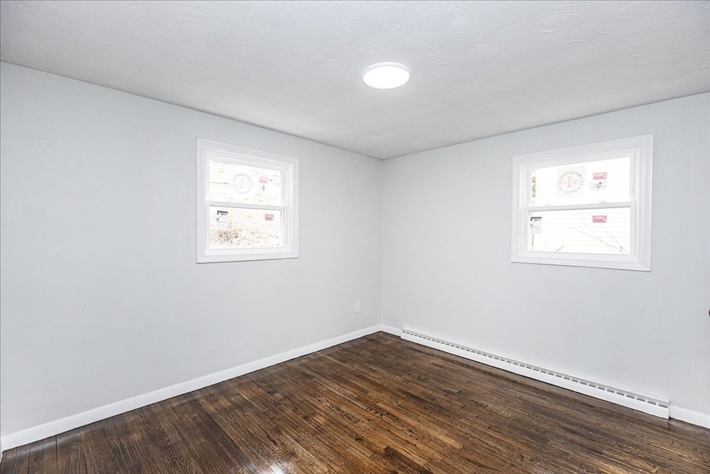38 Warren Street Revere, MA 02151 - Photo 14 of 42 an empty room with wooden floor and windows