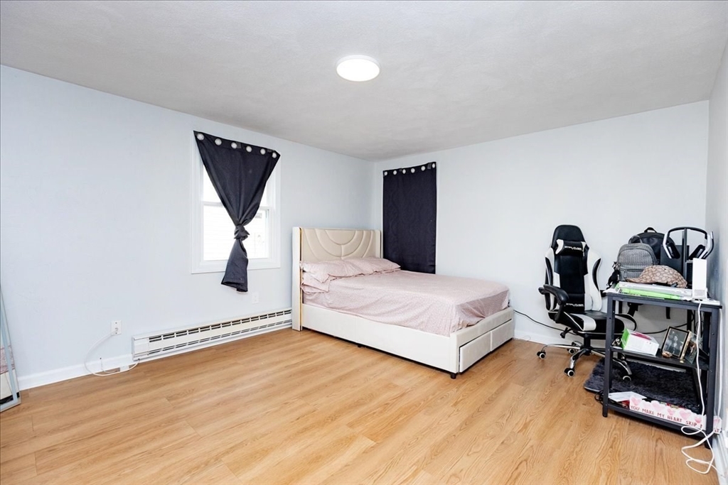38 Warren Street Revere, MA 02151 - Photo 27 of 42 a bedroom with a bed and wooden floor