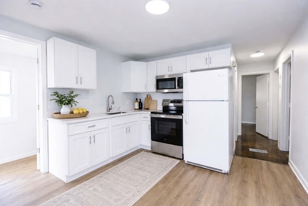 38 Warren Street Revere, MA 02151 - Photo 4 of 42 a kitchen with a refrigerator a stove a microwave and cabinets