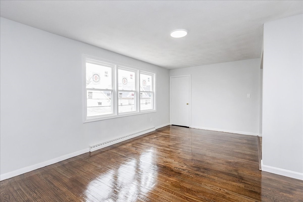 38 Warren Street Revere, MA 02151 - Photo 8 of 42 an empty room with wooden floor and windows