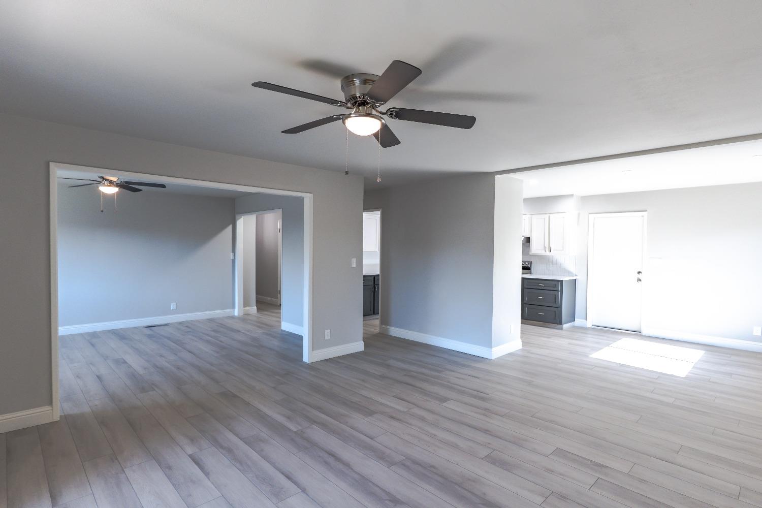 6587 North First Street Fresno, CA 93710 - Photo 11 of 51 a view of an empty room with wooden floor and a ceiling fan