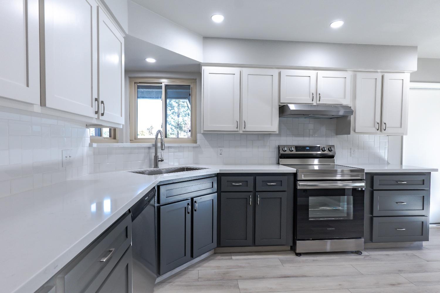 6587 North First Street Fresno, CA 93710 - Photo 15 of 51 a kitchen with stainless steel appliances granite countertop a sink stove and refrigerator