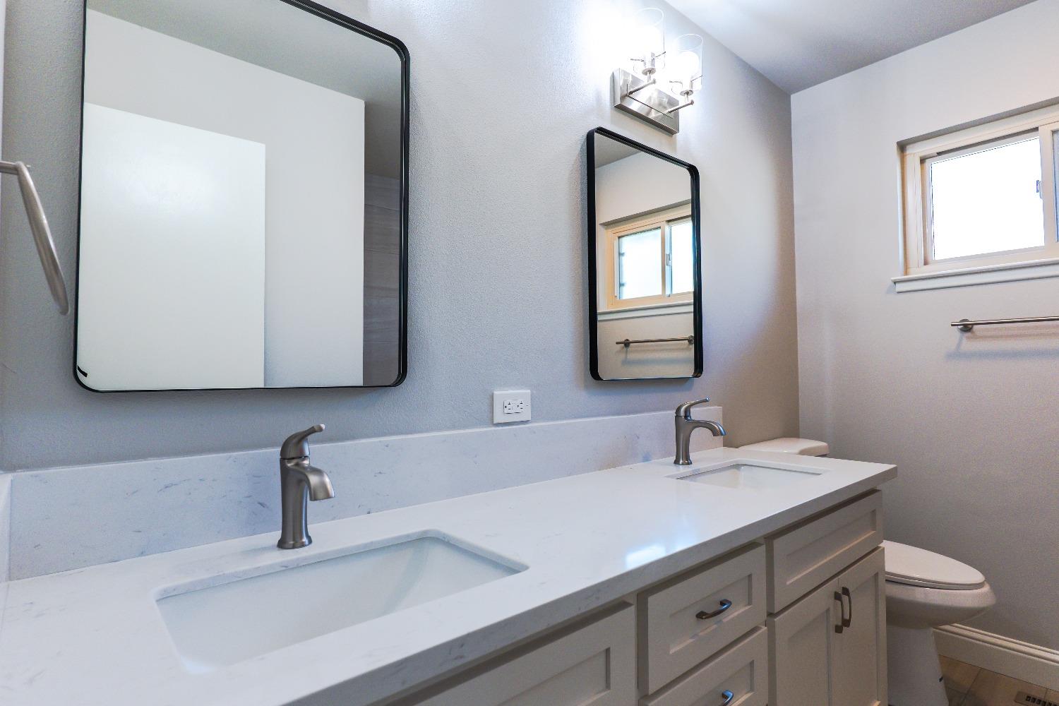 6587 North First Street Fresno, CA 93710 - Photo 25 of 51 a bathroom with a toilet sink and mirror