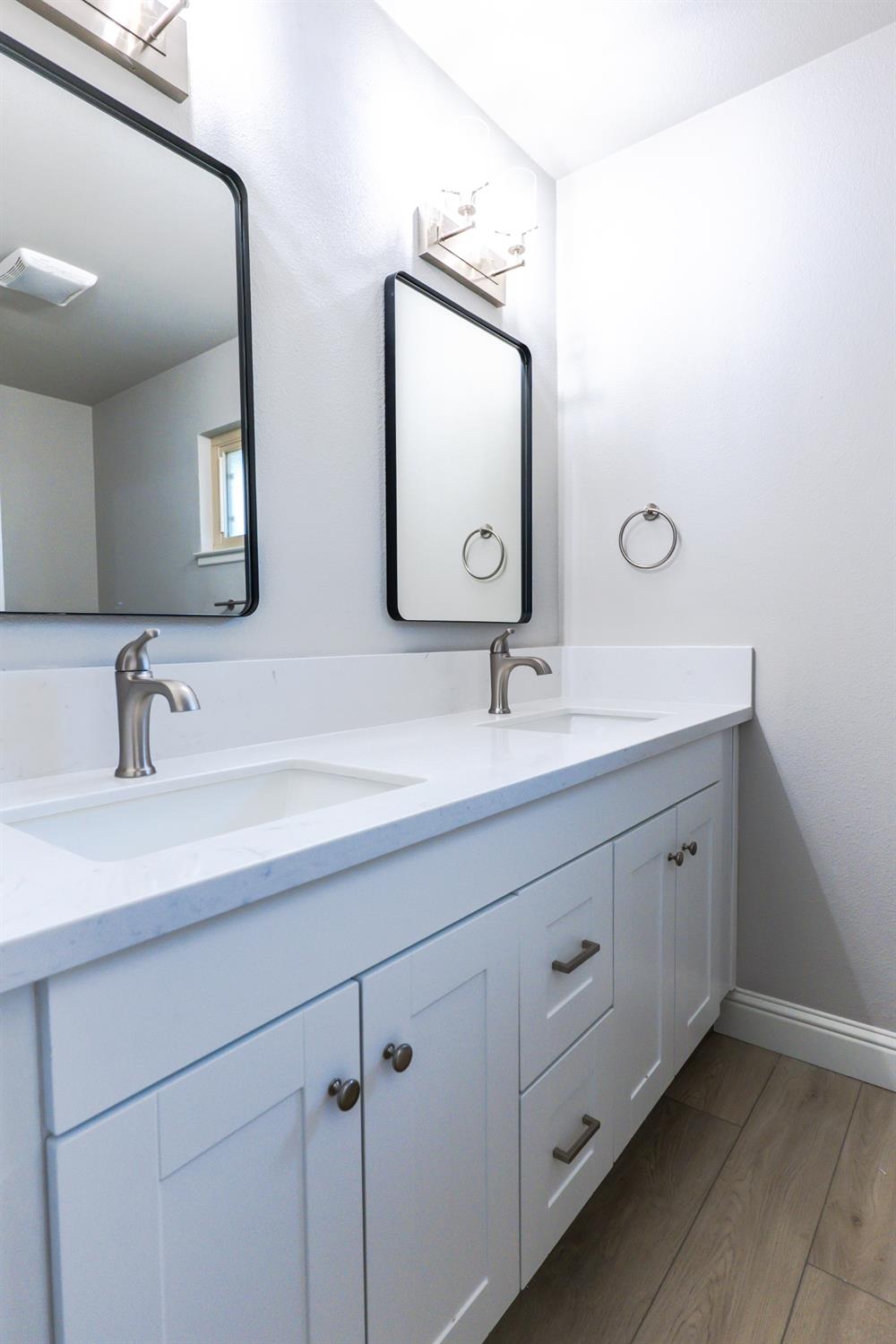 6587 North First Street Fresno, CA 93710 - Photo 34 of 51 a bathroom with a double vanity sink and mirror