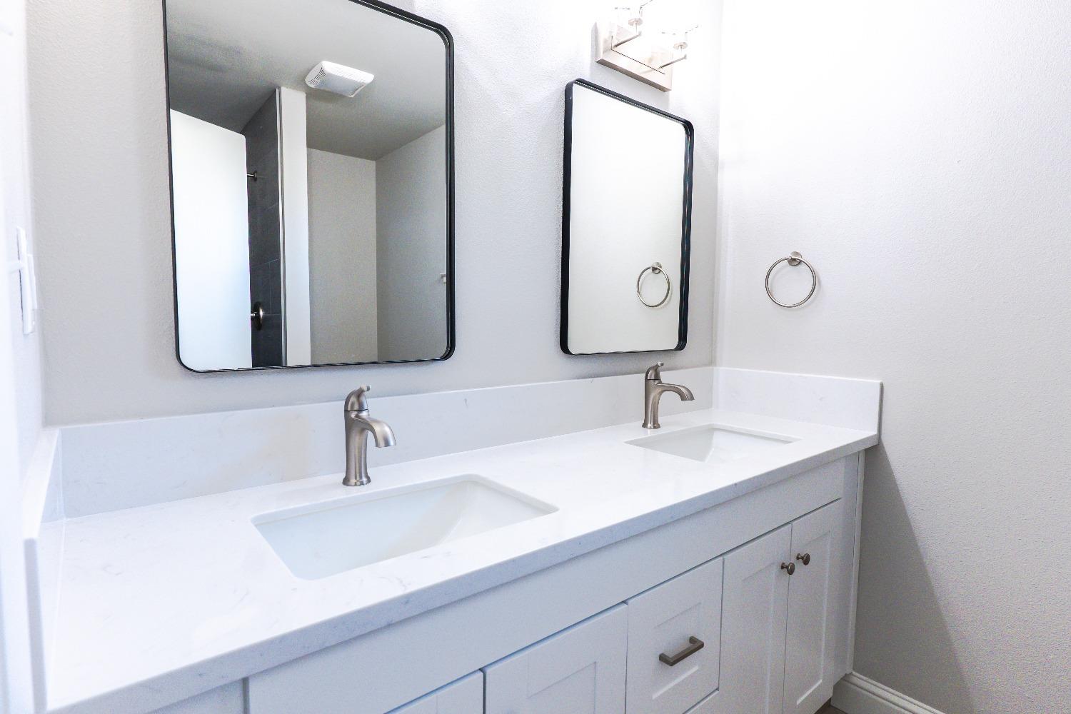6587 North First Street Fresno, CA 93710 - Photo 36 of 51 a bathroom with double vanity sinks and a mirror