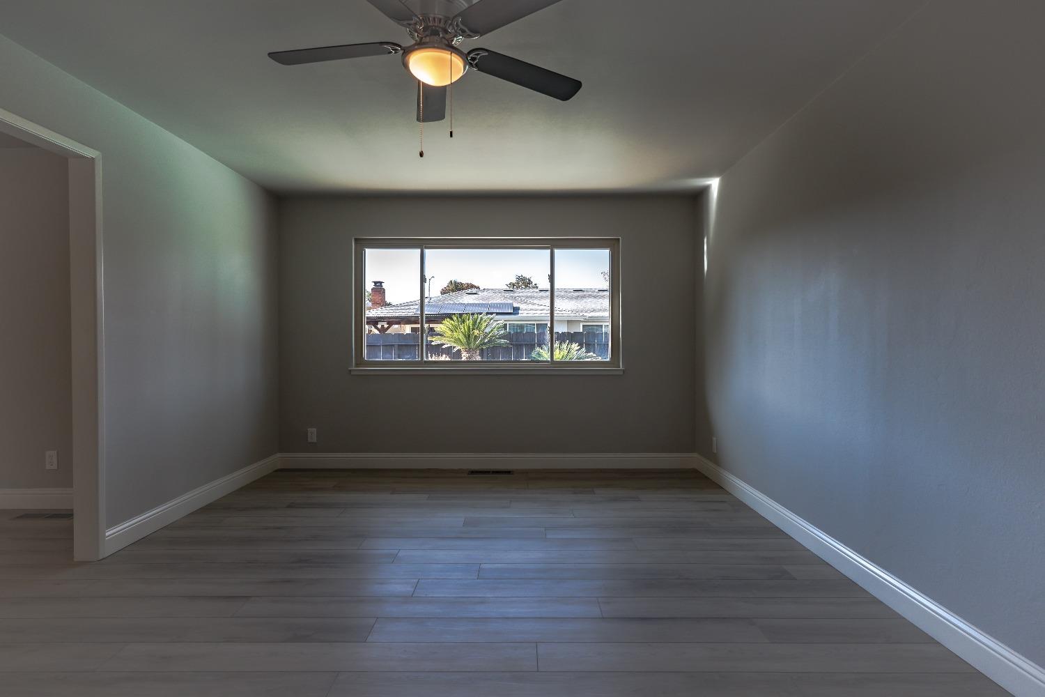 6587 North First Street Fresno, CA 93710 - Photo 6 of 51 an empty room with wooden floor and windows