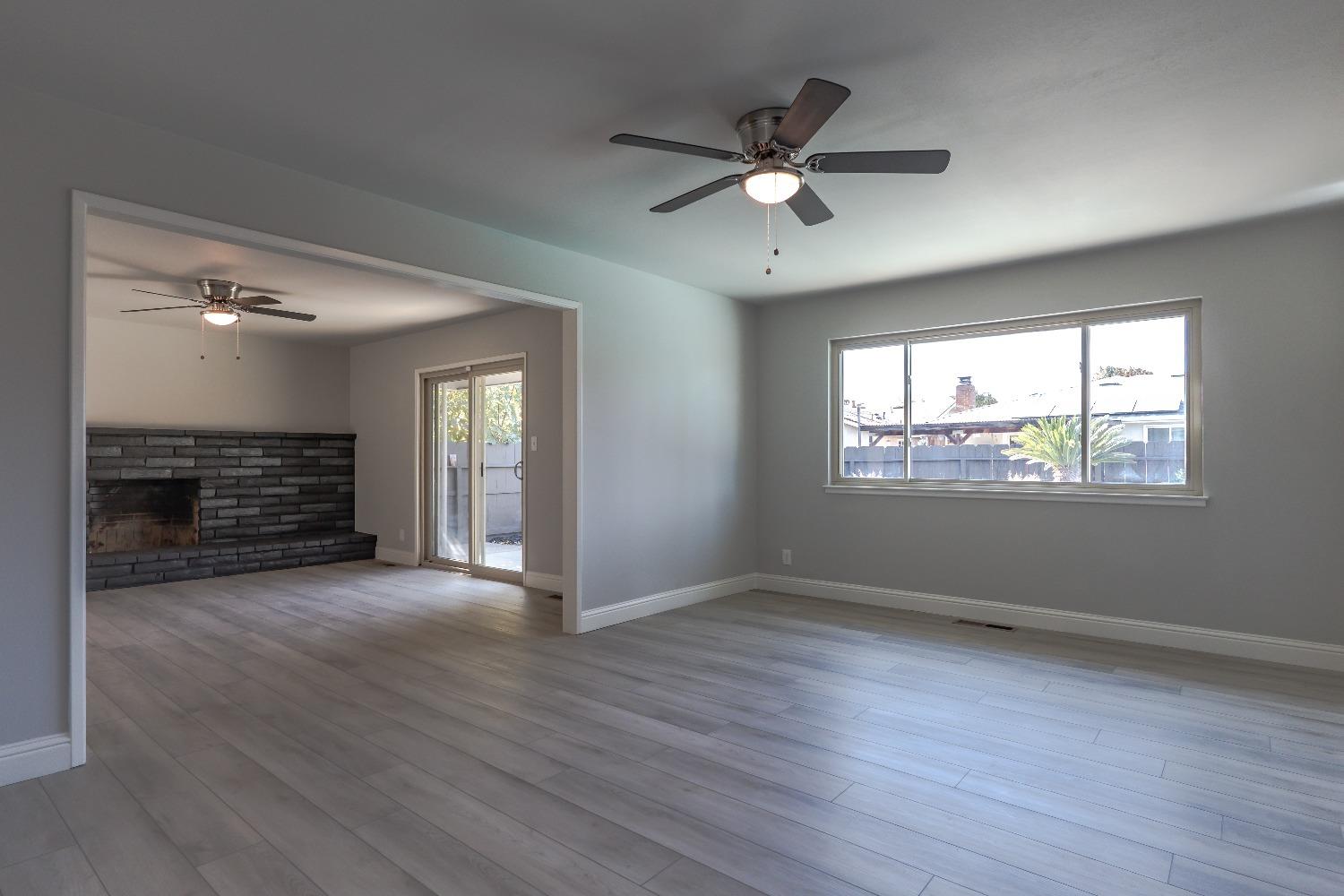 6587 North First Street Fresno, CA 93710 - Photo 7 of 51 an empty room with wooden floor fan and windows