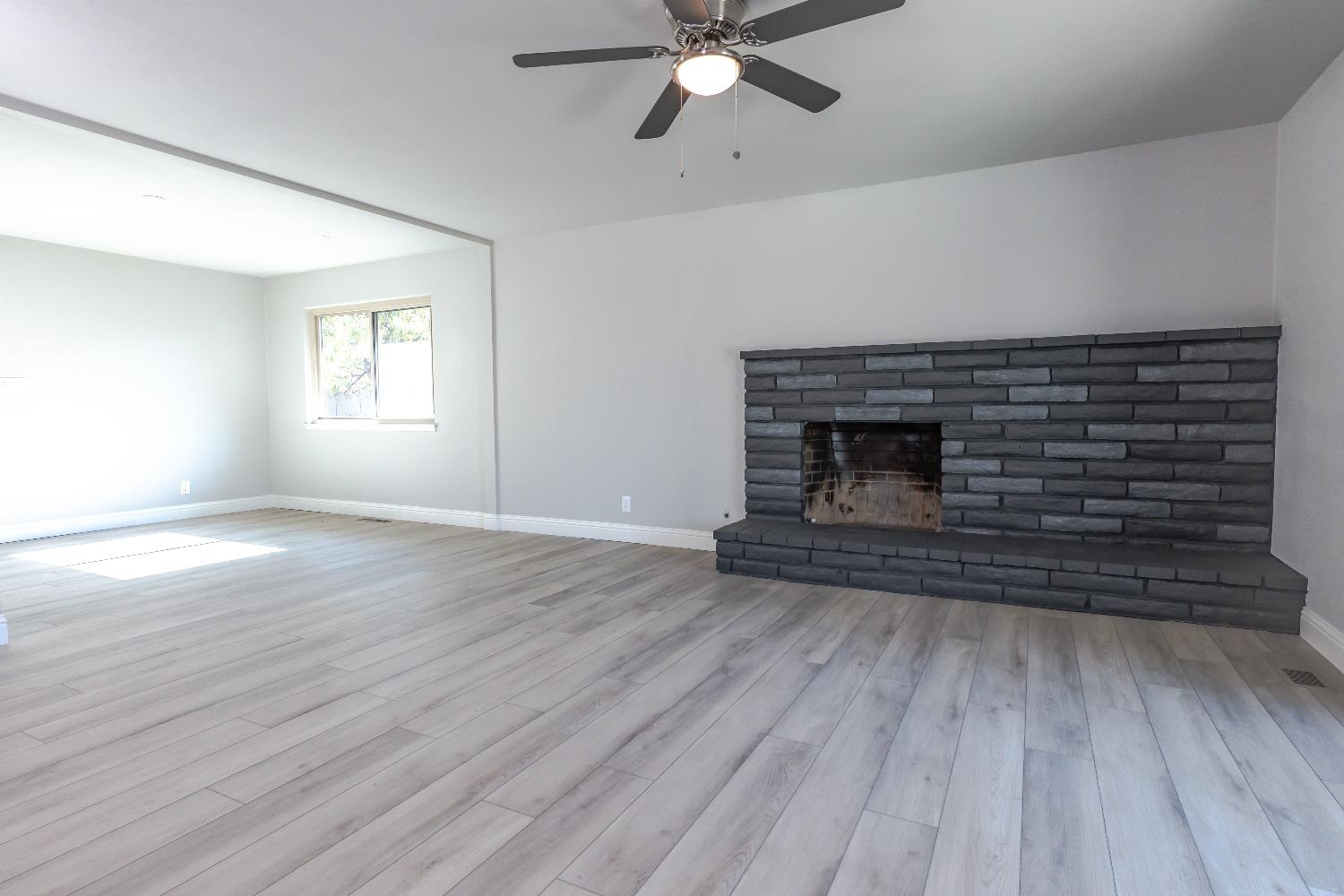 6587 North First Street Fresno, CA 93710 - Photo 10 of 51 a view of an empty room with wooden floor fireplace and a window
