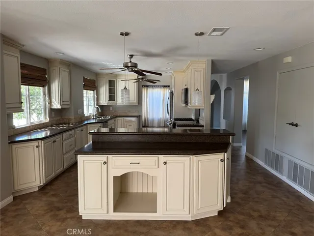 a kitchen with granite countertop a sink and a stove top oven