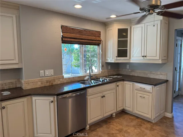 a kitchen with granite countertop a sink and white cabinets