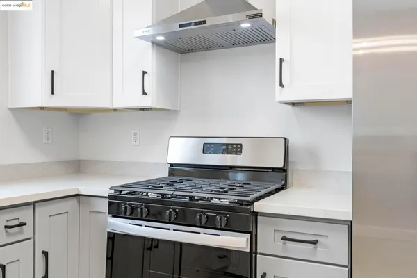 a stove top oven sitting inside of a kitchen