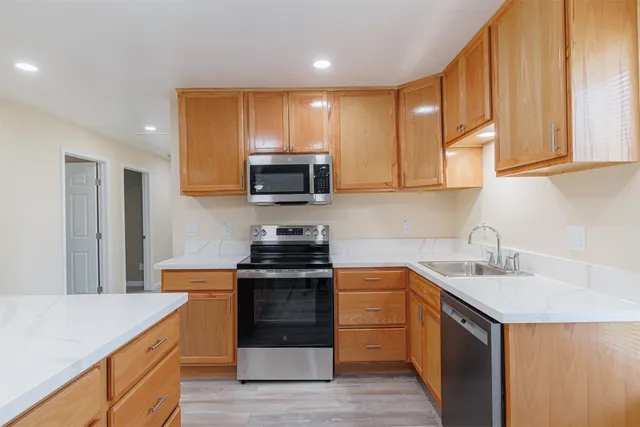 a kitchen with stainless steel appliances granite countertop a sink stove and refrigerator