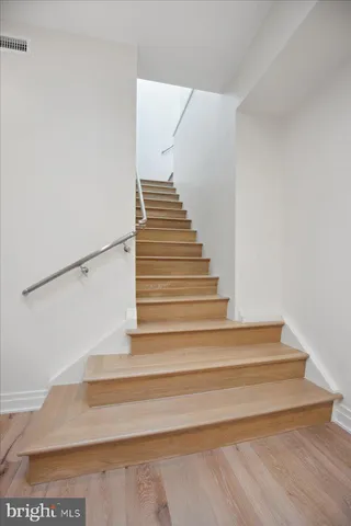 a kitchen with stainless steel appliances kitchen island granite countertop a stove a sink a refrigerator and white cabinets