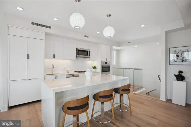 a kitchen with granite countertop a sink stainless steel appliances and cabinets