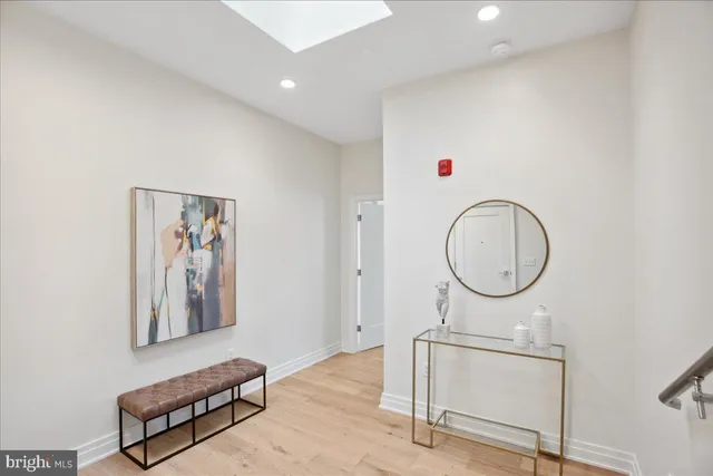 a view of a hallway with wooden floor and cabinet