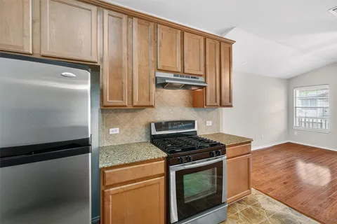 a view of a kitchen with a sink and a refrigerator
