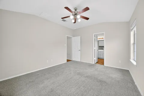 an empty room with a window and a fan