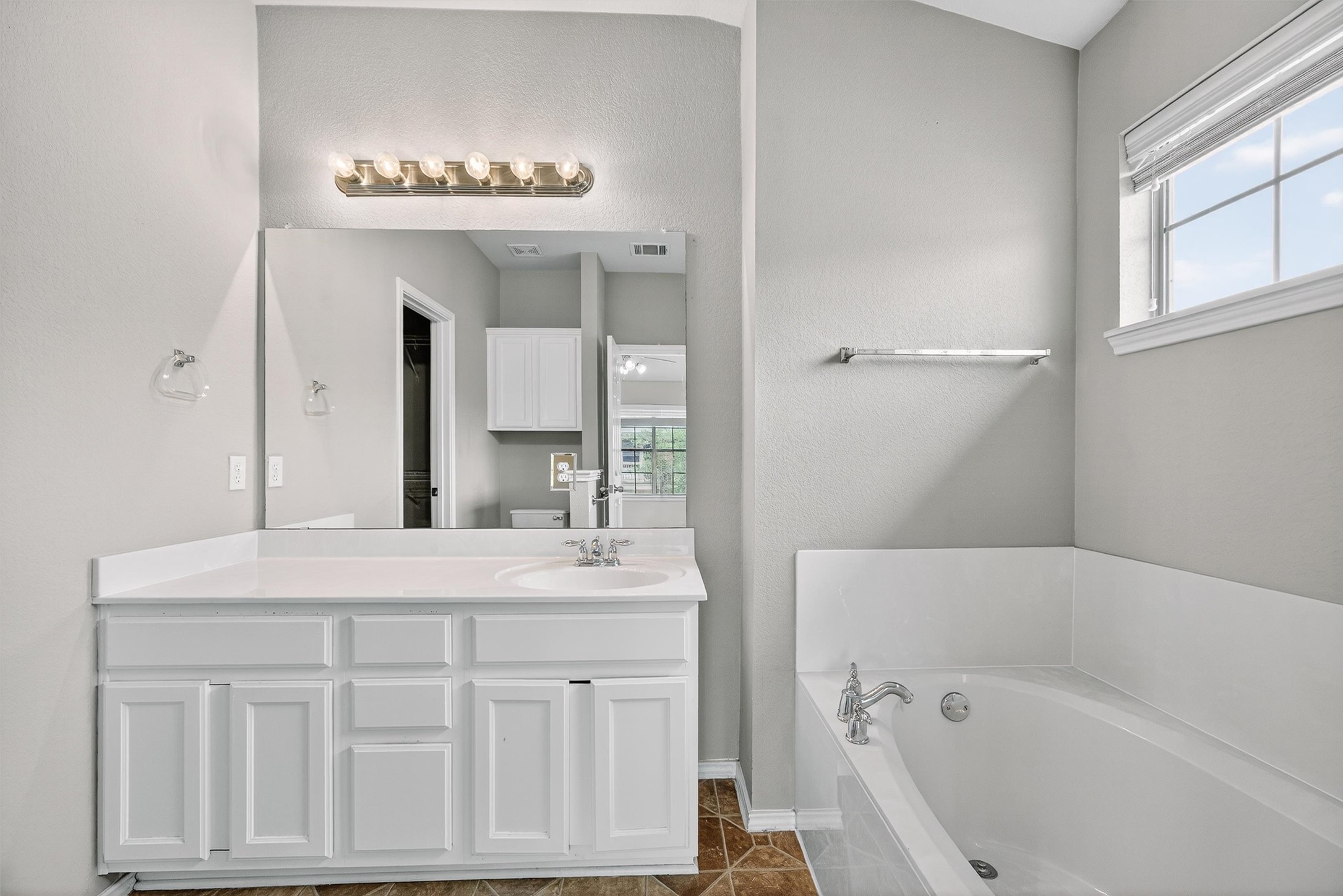 1310 West Parmer Lane, Unit 601 Austin, TX 78727 - Photo 28 of 40 a bathroom with a sink a mirror and a bathtub