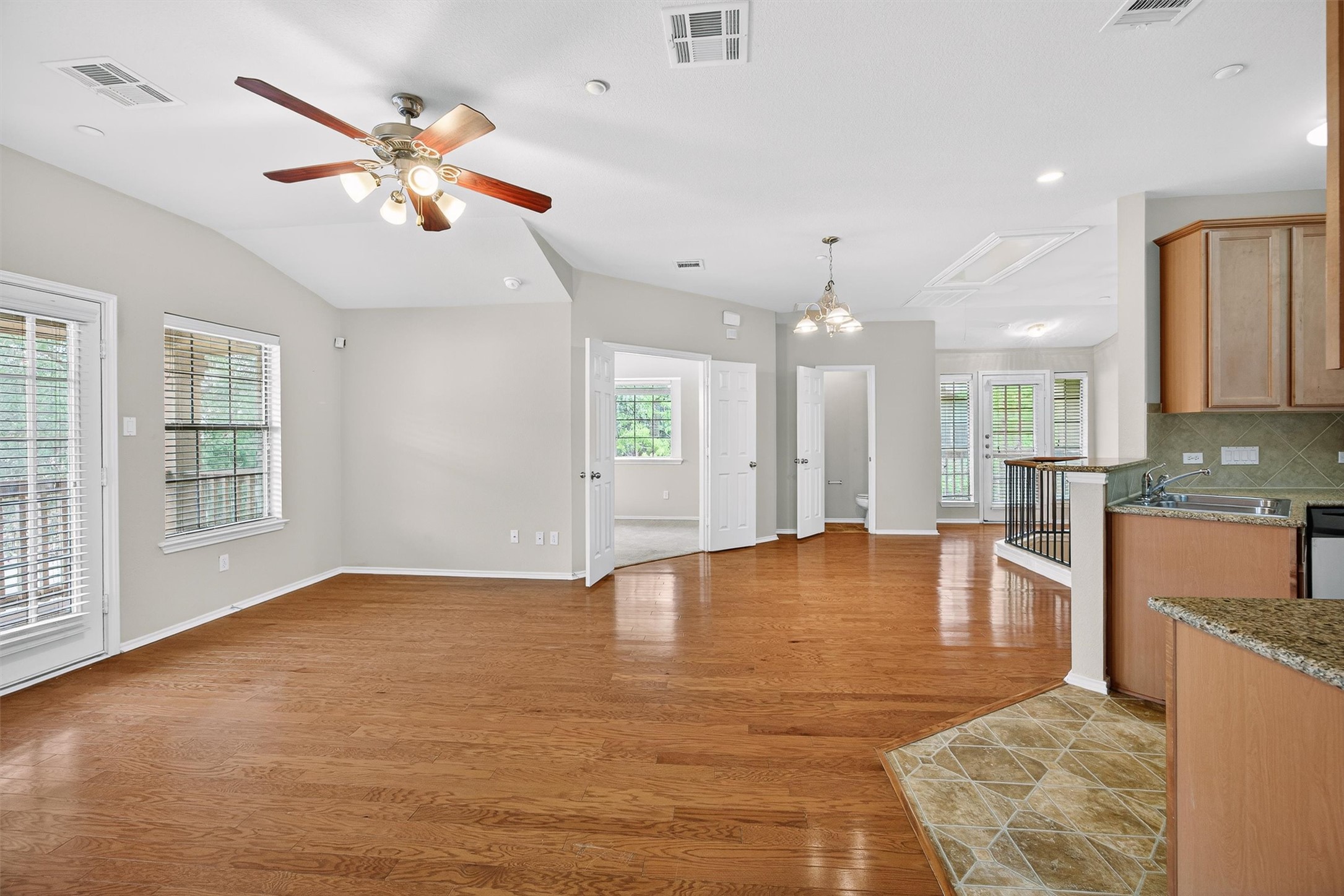 1310 West Parmer Lane, Unit 601 Austin, TX 78727 - Photo 30 of 40 a view of an empty room with chandelier fan and kitchen view