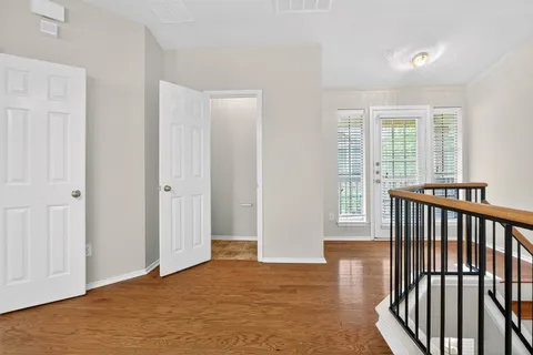 a view of a hallway with wooden floor and chandelier