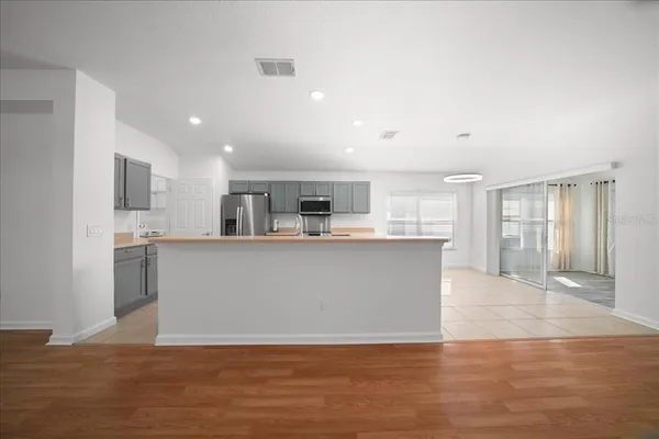 a view of kitchen with kitchen island and stainless steel appliances