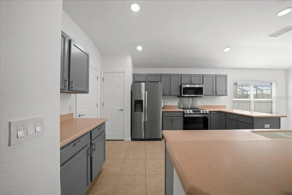 a kitchen with stainless steel appliances a refrigerator sink and microwave