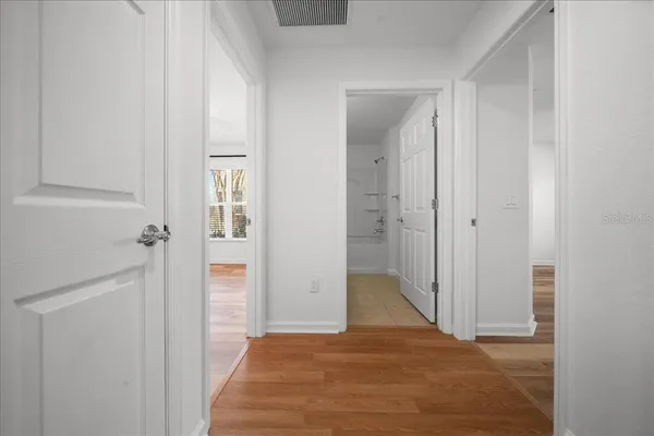 a view of a hallway with wooden floor and closet
