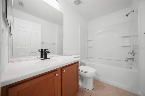 a bathroom with a granite countertop sink a toilet and shower