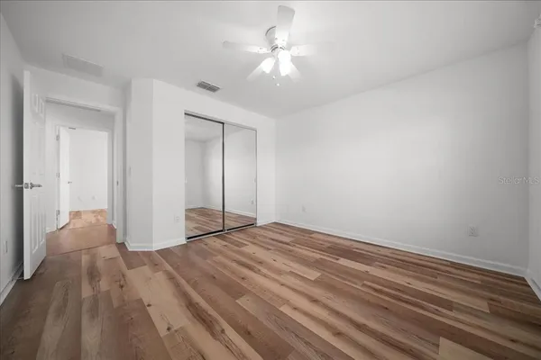 a view of empty room with wooden floor