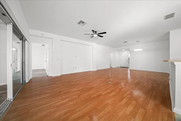 a view of empty room with wooden floor