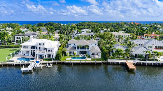 an aerial view of residential houses with outdoor space and lake view