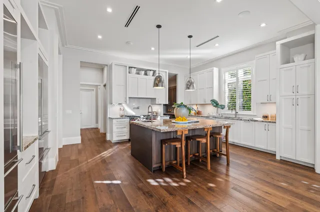 a kitchen with stainless steel appliances kitchen island wooden floors cabinets and stove